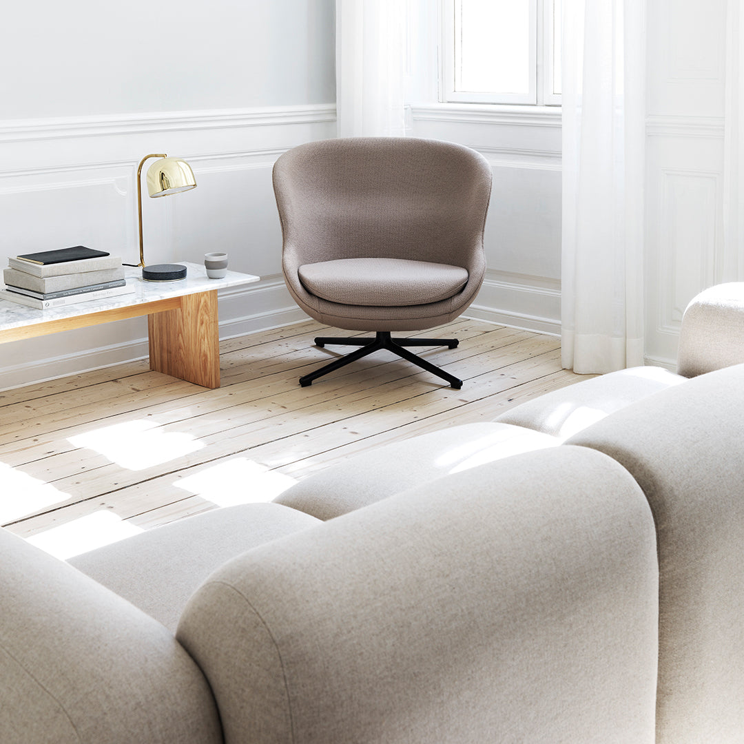 Poltrona lounge imbottita bassa girevole Nordic Hygge con forma avvolgente a sponda alta per il soggiorno
