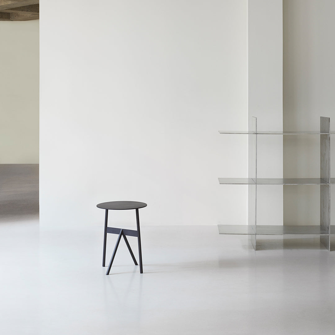 Tavolino d'appoggio minimalista in acciaio con espressione architettonica strutturale per soggiorno