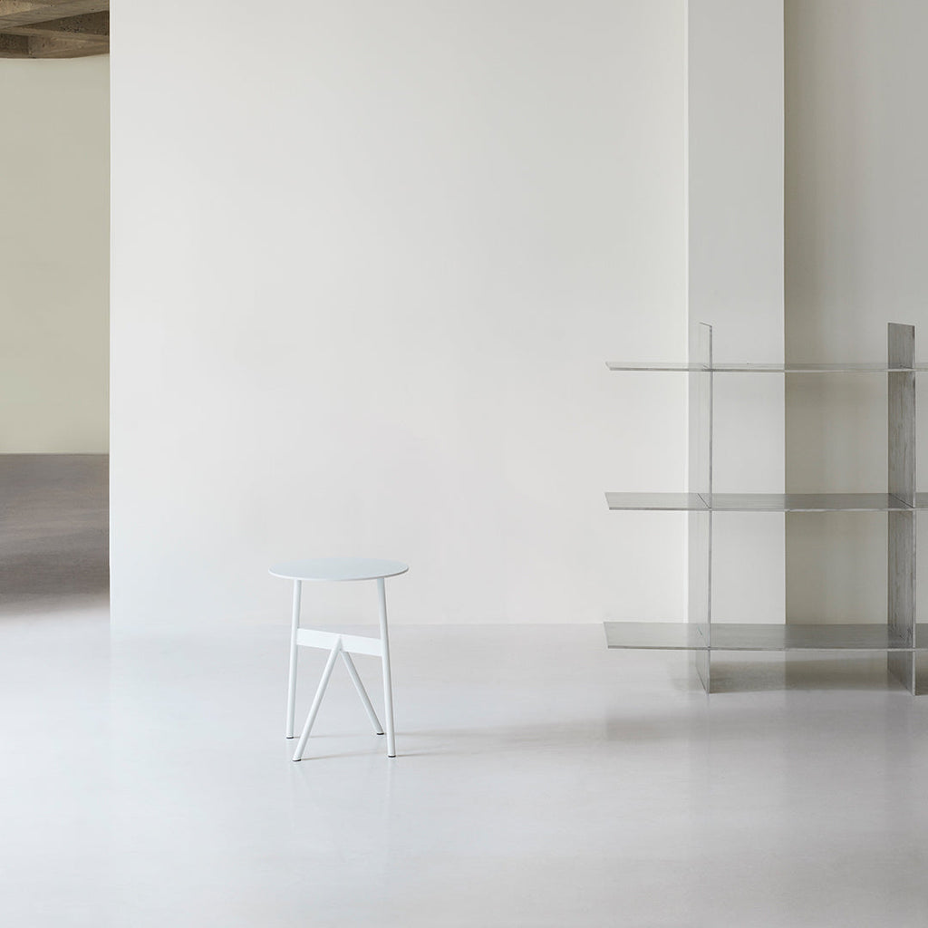 Tavolino d'appoggio minimalista in acciaio con espressione architettonica strutturale per soggiorno