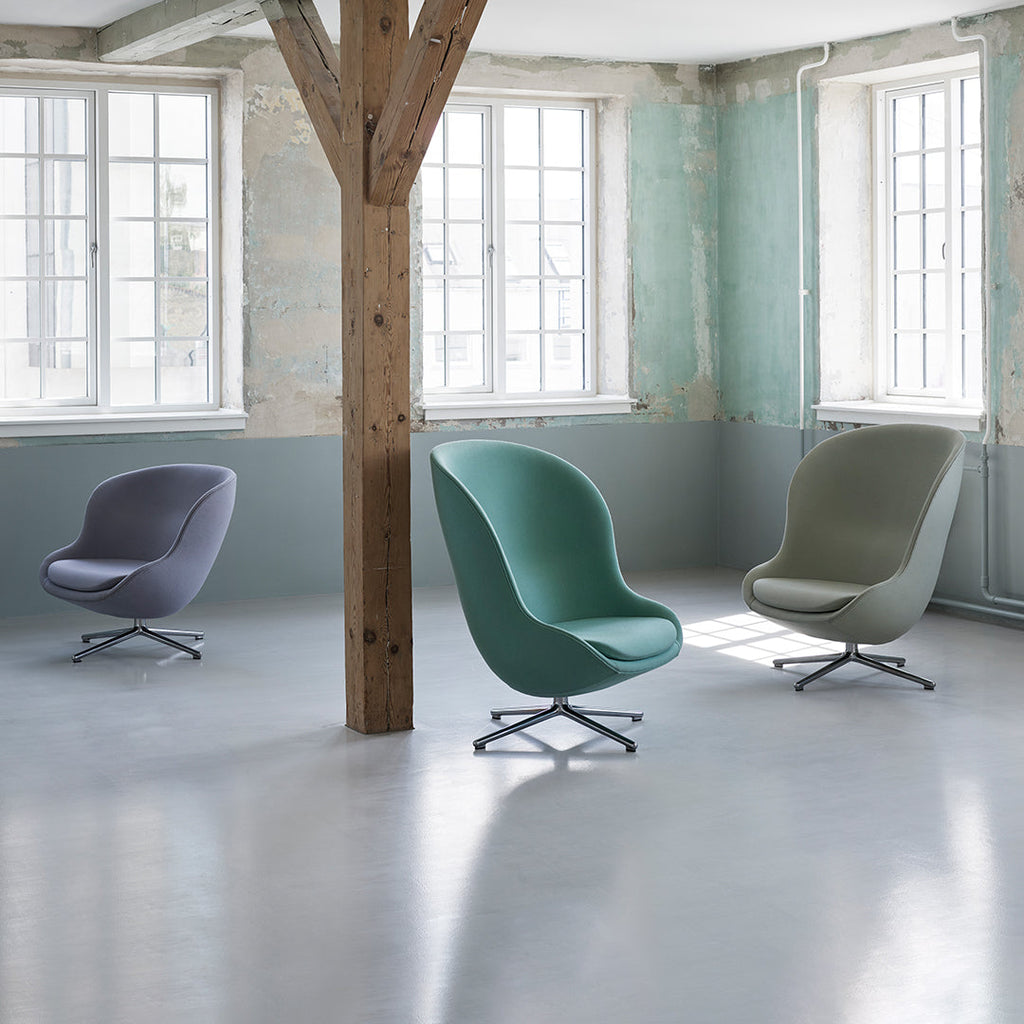 Poltrona lounge imbottita bassa girevole Nordic Hygge con forma avvolgente a sponda alta per il soggiorno