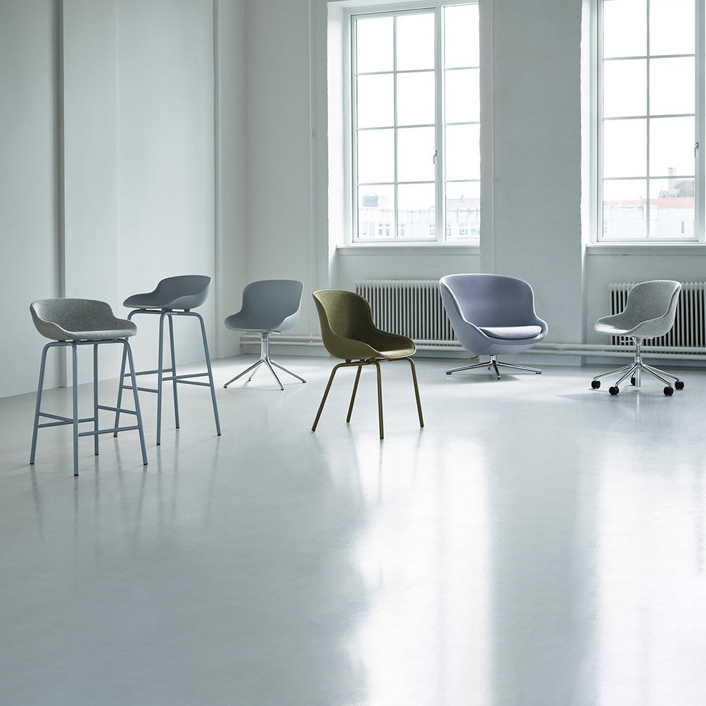 Poltrona lounge imbottita bassa girevole Nordic Hygge con forma avvolgente a sponda alta per il soggiorno